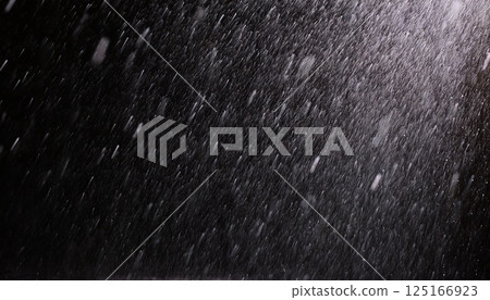 Heavy rain splashes filmed in slow motion against a black background 125166923