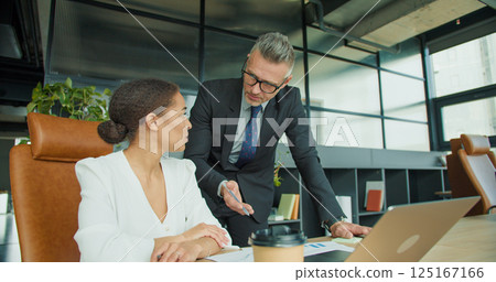 Two professionals reviewing documents in office 125167166