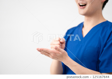 A young man wearing medical scrubs 125167644