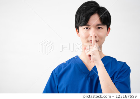 A young man wearing medical scrubs 125167659
