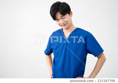 A young man wearing medical scrubs 125167706