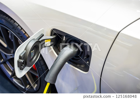 Power cable pump plug in charging power to electric vehicle EV car. 125168048