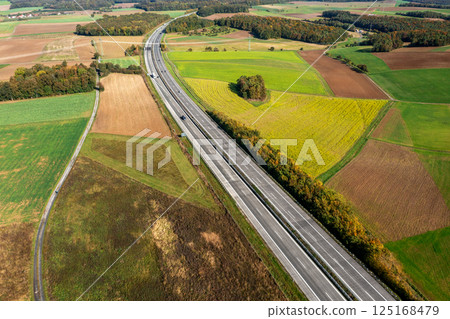 Aerial view of a two-lane highway passing through autumn nature in Germany 125168479