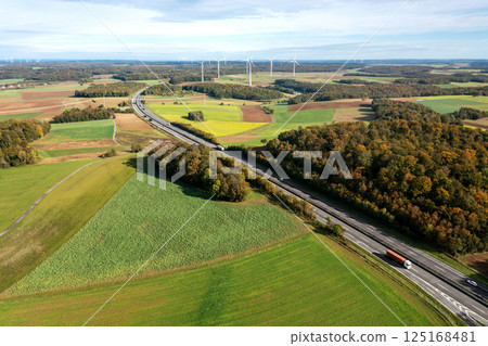 Aerial view with a two-lane highway and wind turbines in an autumn set 125168481