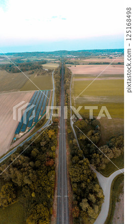 Drone vertical panorama with railroad and solar panels at sunset 125168498