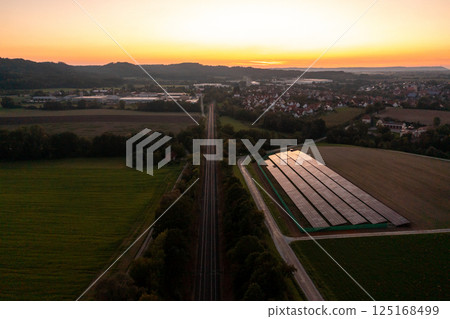 Railtracks and solar panels near a german village, drone aerial view Railtracks and solar panels near a german village, drone aerial view 125168499