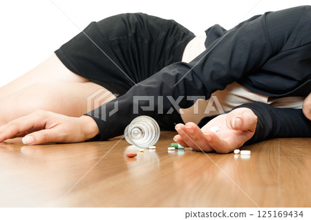 overdose - close up of pills and addict lying on the floor.Health concept 125169434