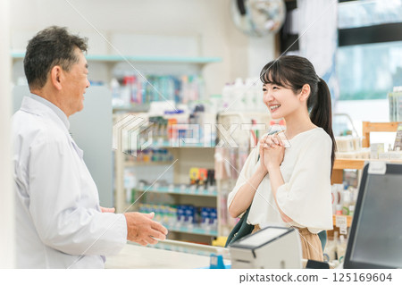 一名婦女和一名藥劑師在藥房/藥店諮詢藥品和處方 125169604