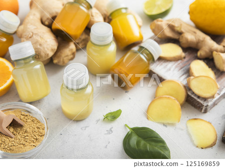 Ginger and turmeric energy shot immune drink with ginger root and turmeric powder on light. Ginger and turmeric energy shot immune drink with ginger root and turmeric powder on light. 125169859
