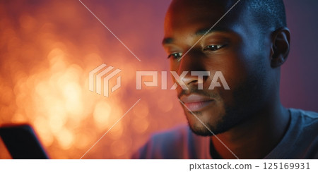 Man is glued to his smartphone, showing the impact of digital distraction and screen fatigue. 125169931