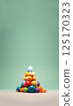 pyramid of colorful Easter eggs, arranged in a festive and artistic manner. The eggs are in pastel and bright tones, symbolizing spring, renewal, and joy. The background is light and airy 125170323