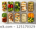 An organized meal prep concept showcasing filled containers with fresh, healthy food, neatly packed in plastic or glass storage boxes 125170329