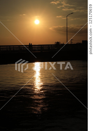 A view of the sun setting over the sea from Katase Bridge near Enoshima 125170659