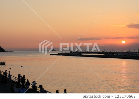 A view of the sun setting over the sea from Katase Bridge near Enoshima A view of the sun setting over the sea from Katase Bridge near Enoshima 125170662