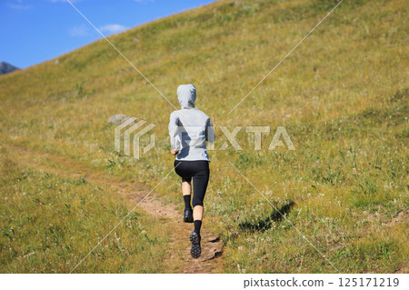Fitness woman runner running in grassland Fitness woman runner running in grassland 125171219