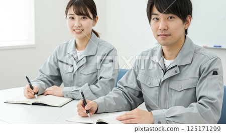 Asian men and women in work clothes undergoing training 125171299