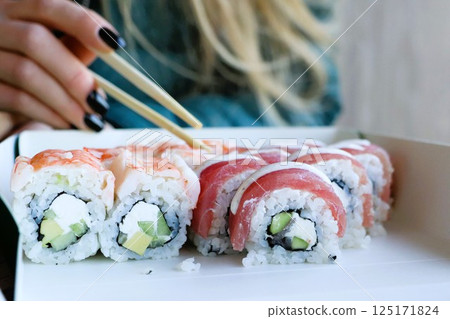 Indulge in Delicious Sushi Rolls Perfectly Crafted and Served with Stylish Chopsticks Indulge in Delicious Sushi Rolls Perfectly Crafted and Served with Stylish Chopsticks 125171824
