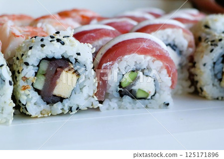 A delightful assortment of Sushi Rolls made with fresh ingredients and a colorful presentation A delightful assortment of Sushi Rolls made with fresh ingredients and a colorful presentation 125171896