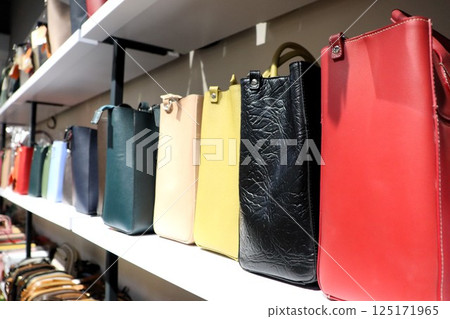 In a chic boutique, discover a vibrant display of elegant, stylish handbags that attract attention 125171965