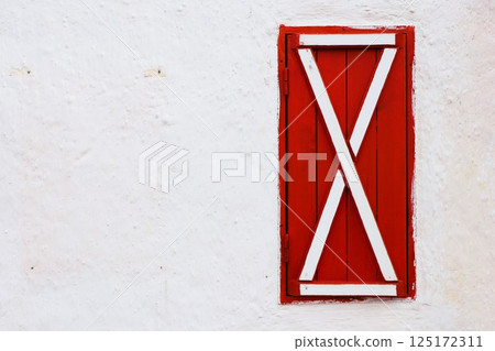 The bright and vibrant red shutter beautifully graced by an elegant white wall structure The bright and vibrant red shutter beautifully graced by an elegant white wall structure 125172311
