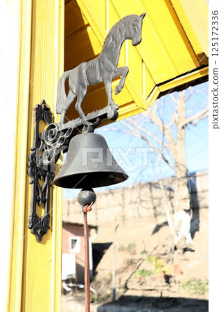 An elegantly designed decorative horse bell installed outside a lovely home for all to see An elegantly designed decorative horse bell installed outside a lovely home for all to see 125172336