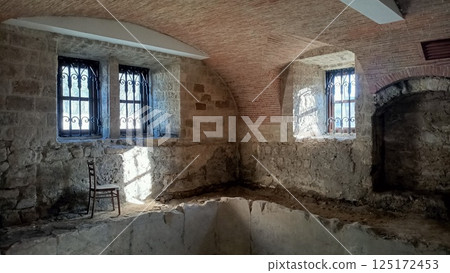 Rustic Interior of a Historical Stone Room that Features Beautiful Windows to the Outside 125172453