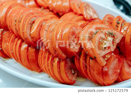 Sliced ripe tomatoes. Tomatoes sprinkled with spices. A useful vegetable. 125172579