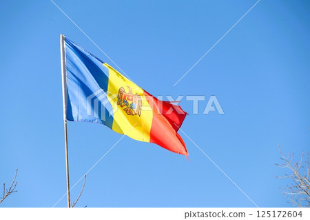 The National Flag of Moldova Waves Proudly Against a Clear and Bright Blue Sky Above 125172604