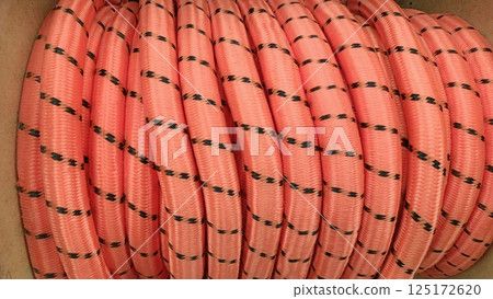 A coiled pink rope that features decorative black dots, perfect for a variety of uses 125172620