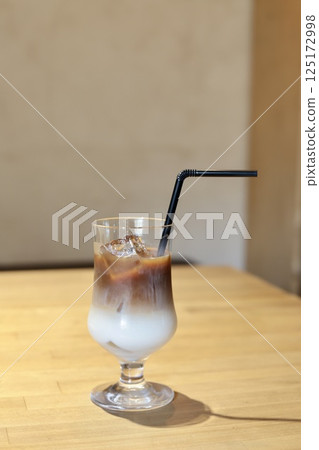 Double-layered iced cafe au lait in a goblet glass 125172998