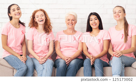 Diverse Ladies In Pink Breast Cancer Awareness T-Shirts Sitting During Support Group Meeting Indoor. Panorama Diverse Ladies In Pink Breast Cancer Awareness T-Shirts Sitting During Support Group Meeting Indoor. Panorama 125173002