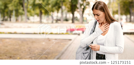 Asthma attack. Asthmatic girl suffering at park, searching for her inhaler in bag, free space 125173151