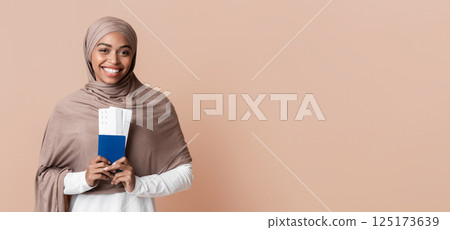 Ready for travel. Happy afro muslim woman in hijab holding passport and tickets, going to vacation, yellow background with empty space Ready for travel. Happy afro muslim woman in hijab holding passport and tickets, going to vacation, yellow background with empty space 125173639