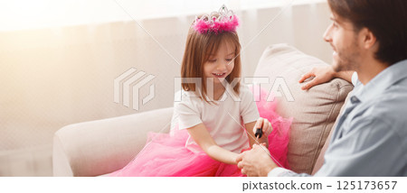 You are best dad. Little pretty princess coloring her dad nails with colorful polisher, close up 125173657