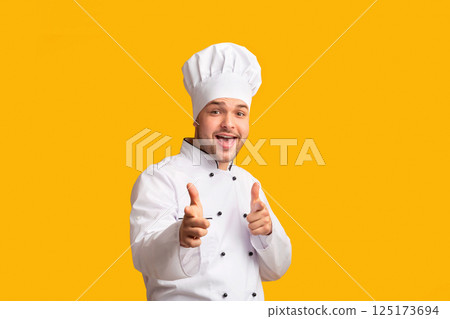 Hey, You. Smiling Chef Man Pointing Fingers At Camera Standing On Yellow Studio Background. Panorama Hey, You. Smiling Chef Man Pointing Fingers At Camera Standing On Yellow Studio Background. Panorama 125173694