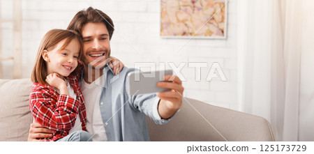 Family portrait. Father and daughter taking selfie on smartphone at home, copy space 125173729