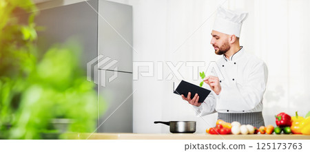 Cooking Food. Chef Man Reading Culinary Recipe Book Preparing Dinner In Restaurant Kitchen Indoor. Cooking Food. Chef Man Reading Culinary Recipe Book Preparing Dinner In Restaurant Kitchen Indoor. 125173763