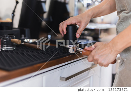 Women barista making coffee in a coffee shop. Women barista making coffee in a coffee shop. 125173871