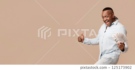 Easy Money, Jackpot, Unexpected Income. Excited mature african american man holding bunch of money and showing thumb up Easy Money, Jackpot, Unexpected Income. Excited mature african american man holding bunch of money and showing thumb up 125173902