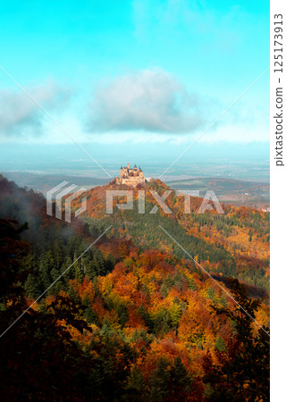 Autumn forest and Hohenzollern castle in Germany, vertical image with a blue sky 125173913