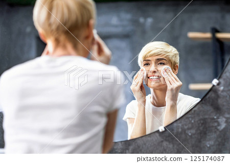 Skin Care. Smiling Woman Using Cotton Pads Applying Moisturizing Lotion Caring For Face Skin Standing In Bathroom Indoor. Selective Focus 125174087