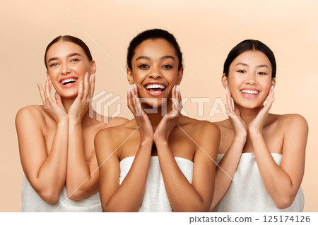 Skincare And Beauty. Three Multiracial Girls Touching Face With Perfect Smooth Skin On Cheeks Smiling At Camera Over Beige Background Skincare And Beauty. Three Multiracial Girls Touching Face With Perfect Smooth Skin On Cheeks Smiling At Camera Over Beige Background 125174126