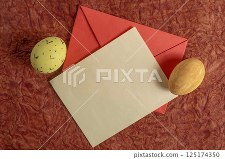 Easter themed flat lay with decorative eggs, envelope, and rustic background. Easter themed flat lay with decorative eggs, envelope, and rustic background. 125174350
