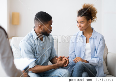 African American Husband Apologizing And Making Up With Wife After Quarrel At Couples Psychologist's Office. Selective Focus 125174495