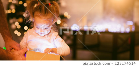Cherished present. Little girl enjoying her glowing Christmas present at home Cherished present. Little girl enjoying her glowing Christmas present at home 125174514