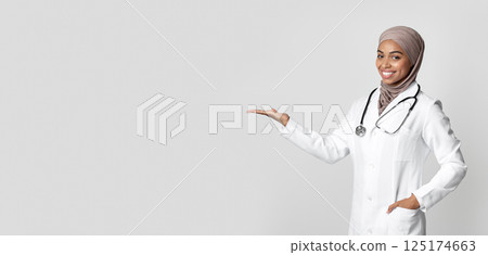 Effective Flu Remedy. Young Black Female Doctor Holding Invisible Item On Her Palm, Showing New Vitamin Complex, Demonstrating Pack With Medicine Effective Flu Remedy. Young Black Female Doctor Holding Invisible Item On Her Palm, Showing New Vitamin Complex, Demonstrating Pack With Medicine 125174663