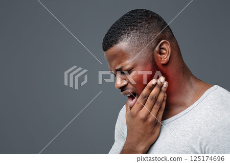 Young afro man having acute toothache, holding his jaw, copy space Young afro man having acute toothache, holding his jaw, copy space 125174696