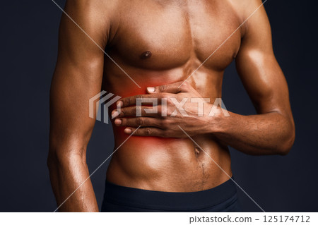 Left Side Pain. Handsome black bodybuilder with red dot suffering from gastritis, sore zone, shirtless torso 125174712
