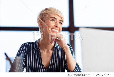 Successful Businesswoman. Happy Lady Sitting At Workdesk Smiling Working In Modern Office. Selective Focus Successful Businesswoman. Happy Lady Sitting At Workdesk Smiling Working In Modern Office. Selective Focus 125174938