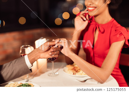 Loving Spouses Holding Hands Having Romantic Date Celebrating Anniversary Of Relationship Sitting In Restaurant. Cropped, Selective Focus Loving Spouses Holding Hands Having Romantic Date Celebrating Anniversary Of Relationship Sitting In Restaurant. Cropped, Selective Focus 125175055